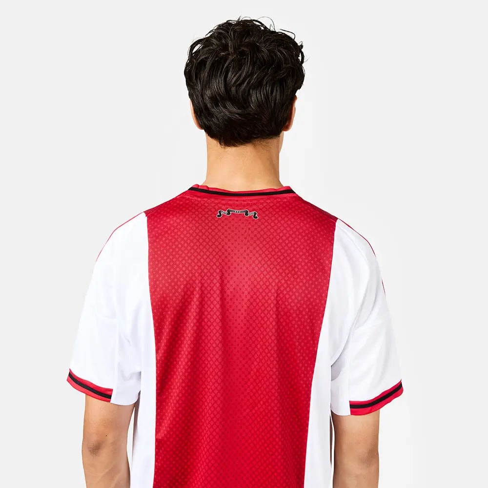 b57cebdc-595c-d8ae-68c6-1b045b0f968a | AE JERSEY Back view of a person wearing a red and white mesh soccer jersey, with a small logo at the upper back.