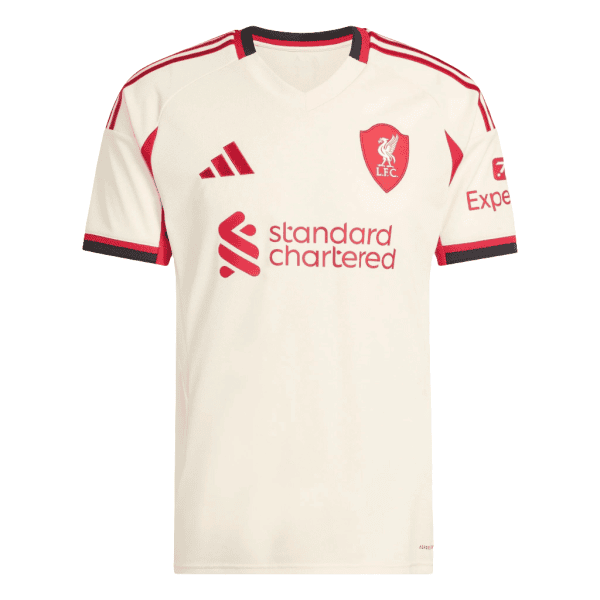 Cream-colored Liverpool FC football jersey with red crest, sponsor logo 'Standard Chartered', and red accents along shoulders and sleeves