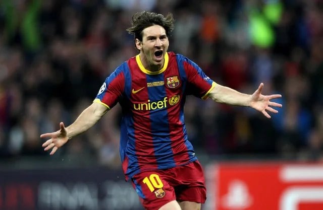 barcelona-classic-201011-final-with-messi-10-badges-jersey-384624 | AE JERSEY Soccer player in a blue-and-red Barcelona jersey (#10) celebrates a goal with arms outstretched.