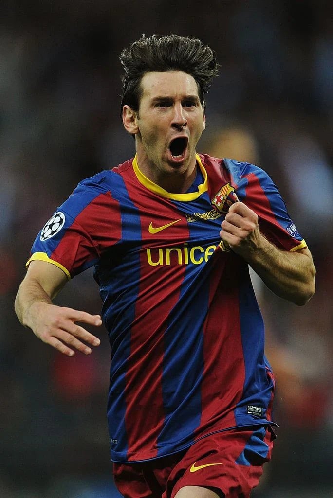 barcelona-classic-201011-final-with-messi-10-badges-jersey-653337 | AE JERSEY Male soccer player in a blue and maroon Barcelona kit celebrates a goal, mouth open in a yell and fist clenched.