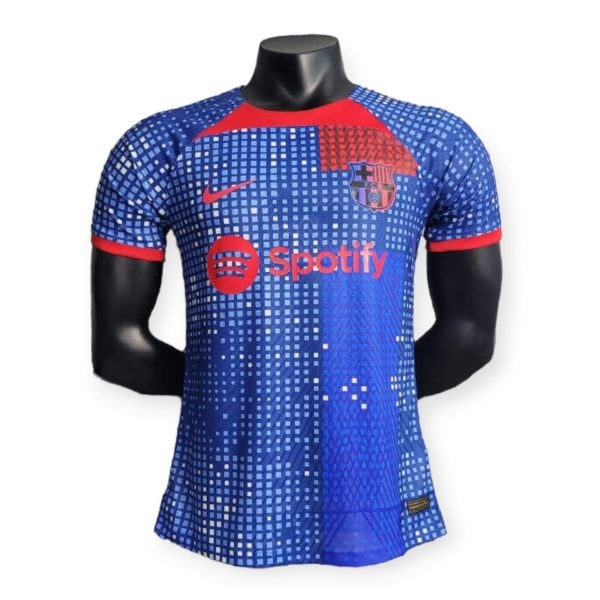 Mannequin wearing a blue FC Barcelona soccer jersey with a pixelated pattern and Spotify logo on the chest.