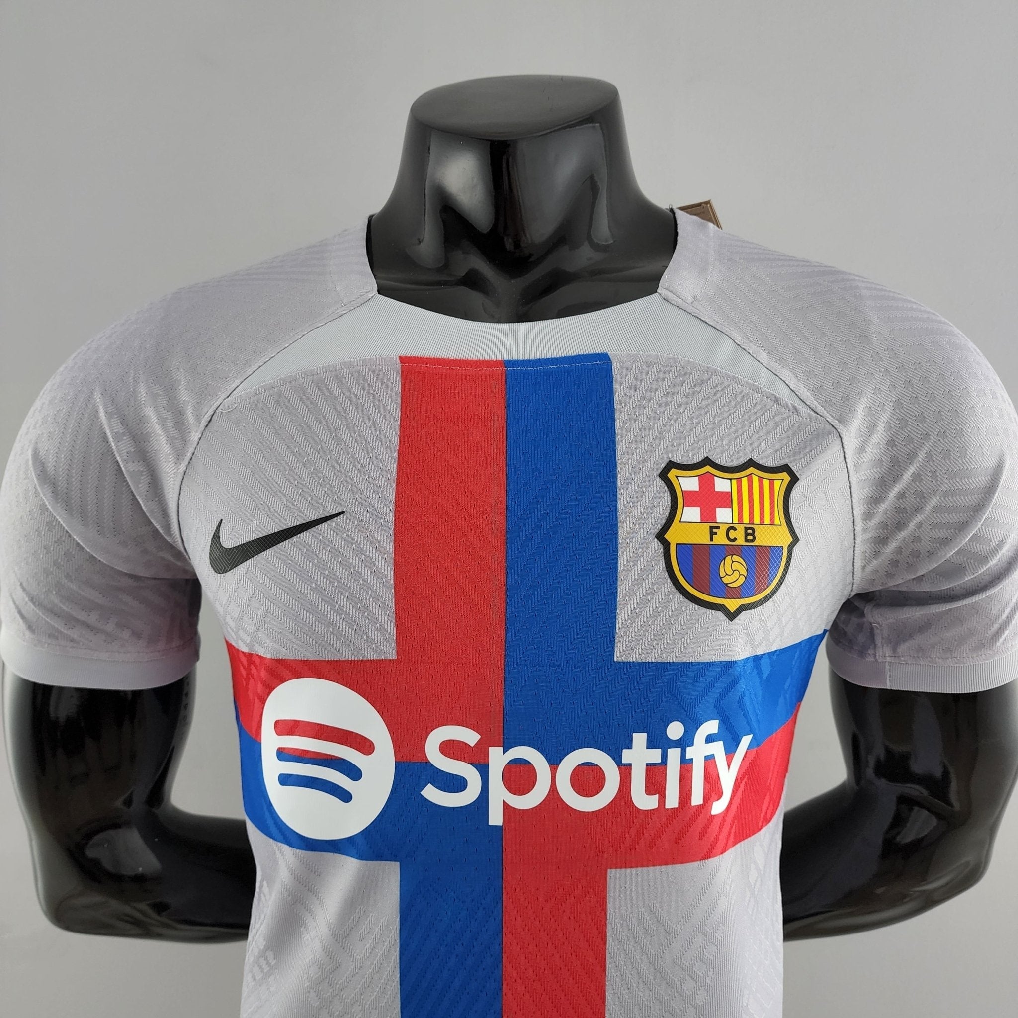 barcelona-third-player-version-jersey-202223-130896 | AE JERSEY Grey FC Barcelona soccer jersey on a headless mannequin, with a red-blue vertical stripe and the Spotify sponsor logo visible on the front.