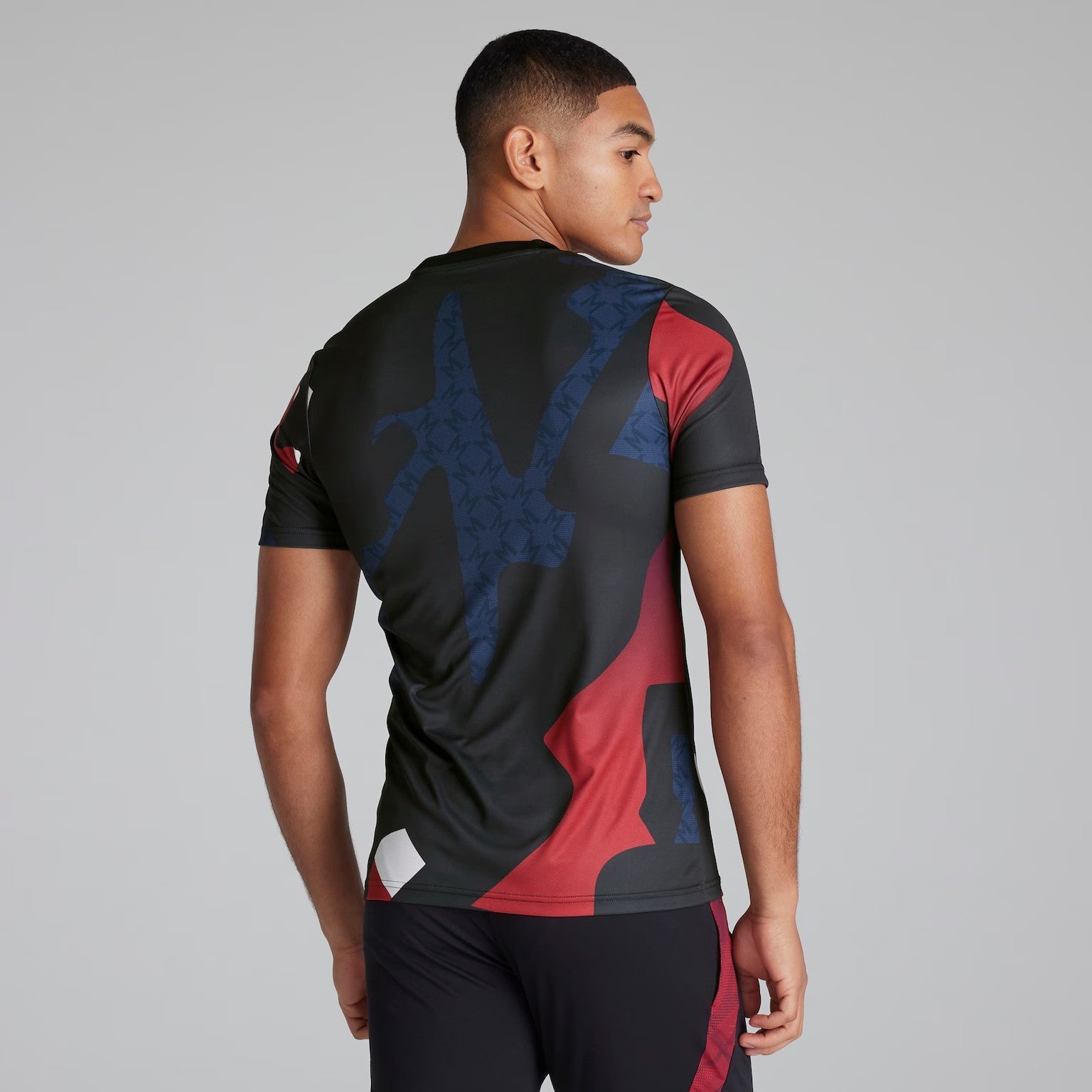 brDjYY1aL4trXXQ | AE JERSEY Back view of a man wearing a black, red, and dark blue abstract-pattern athletic jersey against a gray background.