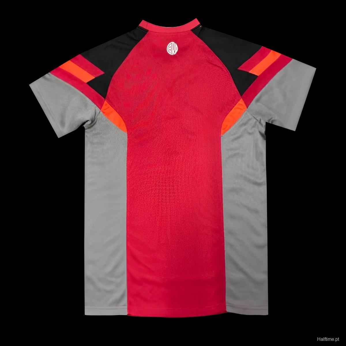 c1572812fa1b6a7b13c617b9 | AE JERSEY Front view of a red and gray athletic jersey with black shoulders and orange accents; small white circular logo at the neckline.