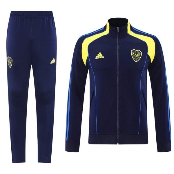 Navy blue Adidas tracksuit with yellow accents; zip-up jacket with club crest and matching pants.