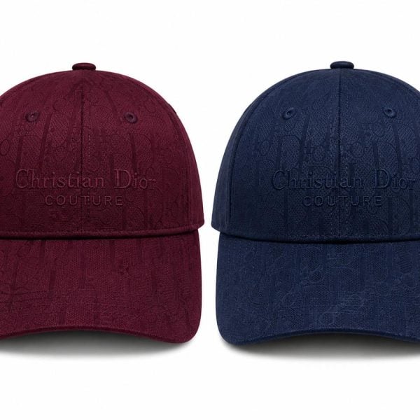 Two Christian Dior Couture baseball caps in burgundy and navy, featuring a subtle Dior monogram pattern and embossed logo on the front panel.