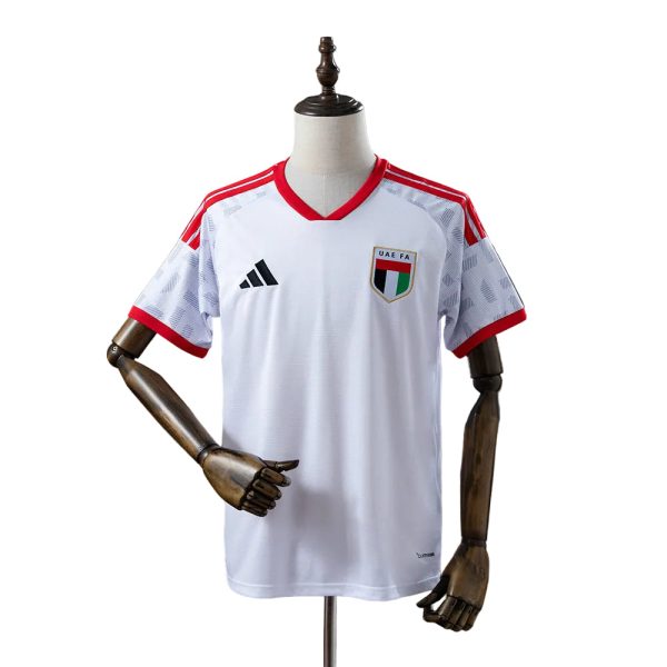 White UAE FA soccer jersey on a mannequin with red trim at the neck and sleeves, Adidas logo visible on the chest.