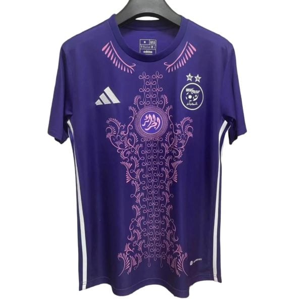 Purple athletic jersey with pink ornamental floral pattern and Arabic crest on the chest, Adidas logo visible on the left.