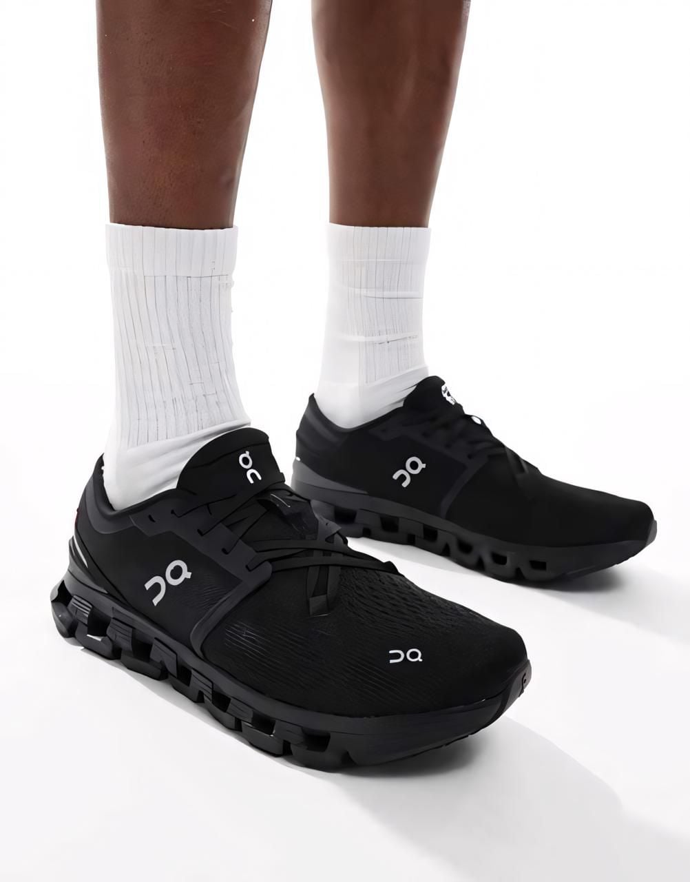 d46424d2-46c8-44da-8ad4-d3f119112989 | AE JERSEY Black On running shoes worn with white socks, shown from the ankle down against a white background.