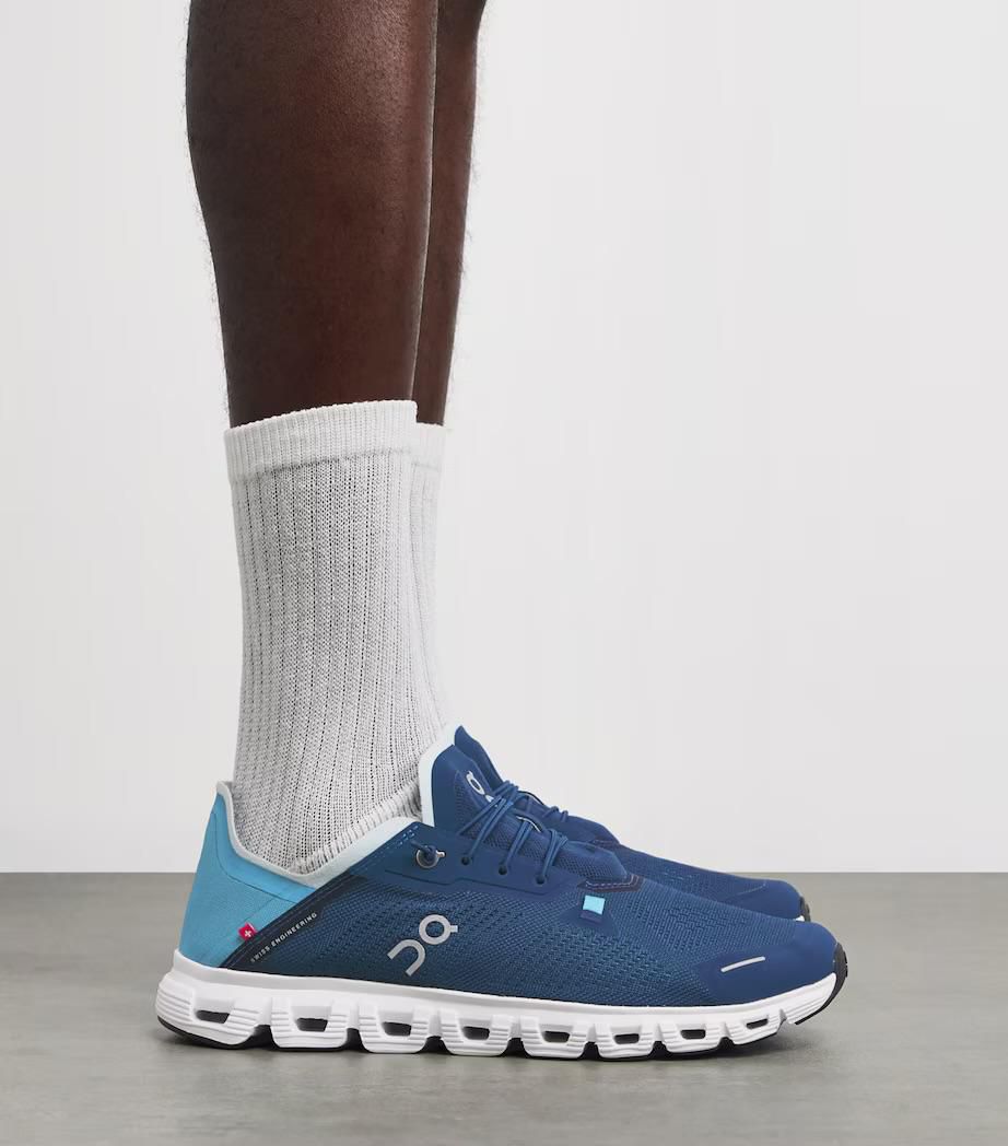 d4d0c179-adf8-4eea-ade3-91861190c0cb | AE JERSEY Blue running shoes with a white segmented sole, worn with white crew socks, side view.