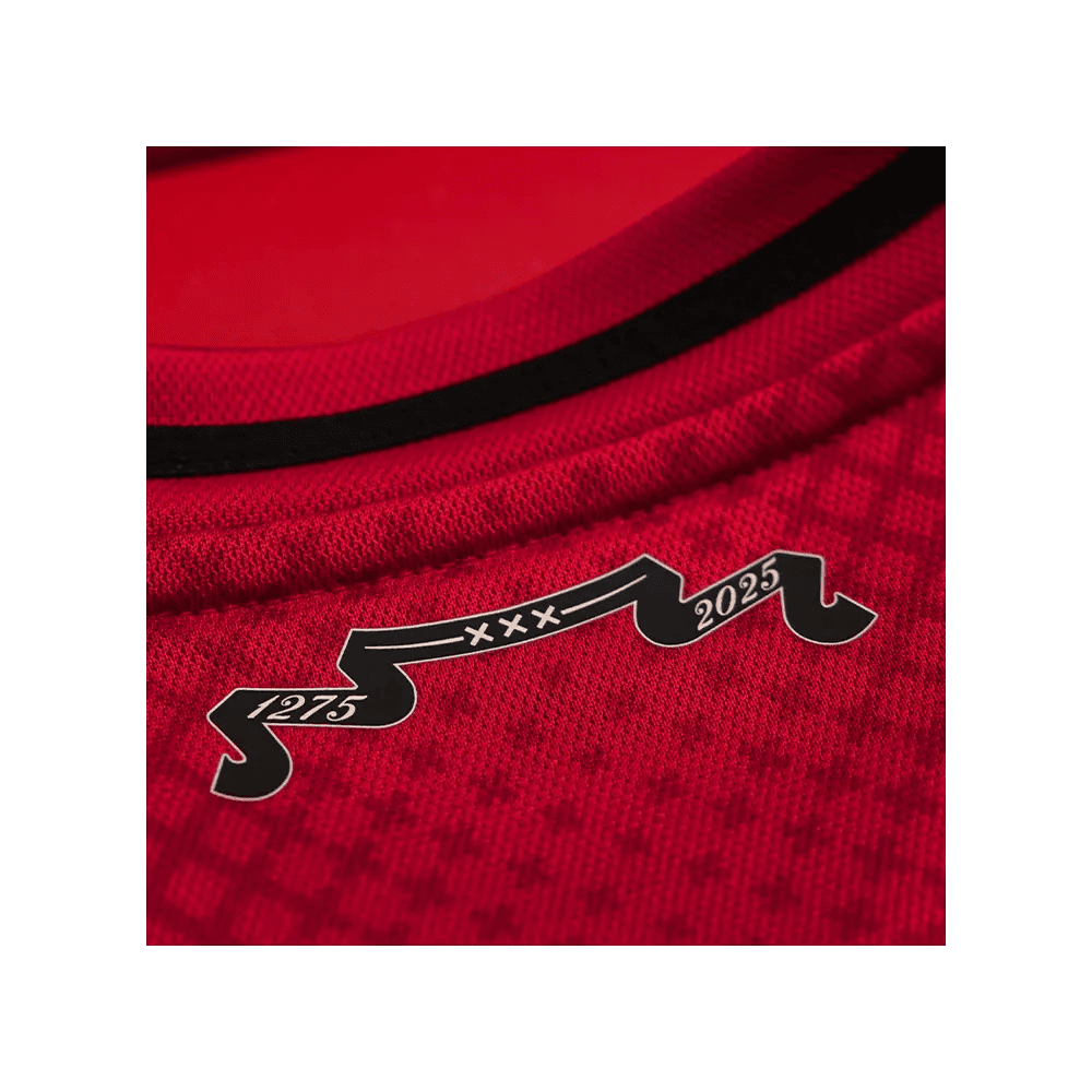 d6f4a9f8-0d24-baaa-b327-308e3dced738 | AE JERSEY Close-up of red sports jersey fabric with a black decorative ribbon showing the years 1275 and 2025 (and XXX).