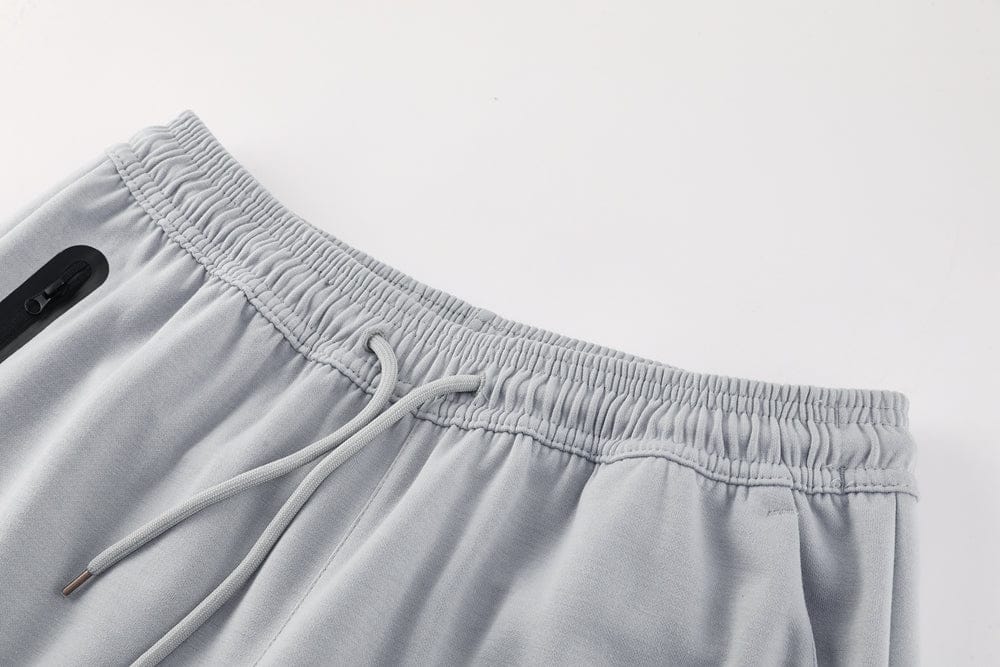 d70f6af0 | AE JERSEY Close-up of light gray jogger pants waistband with drawstring and zip pocket similar detail visible near the left edge.