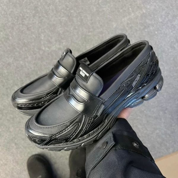 Black chunky athletic sneakers with two Velcro straps and a thick, textured sole.