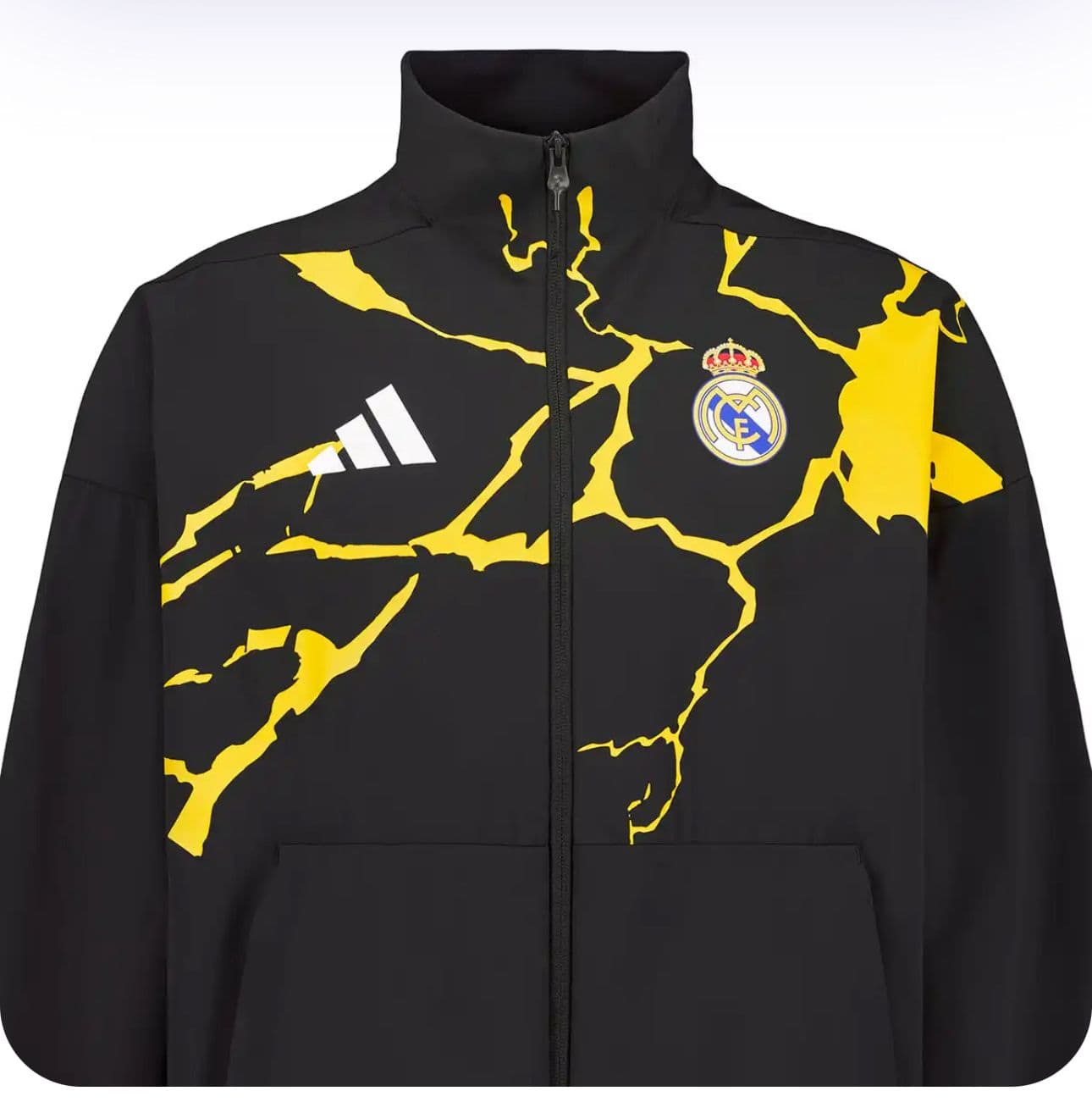 dfc41381-d891-4855-a1c2-9919b4689758 | AE JERSEY Black Real Madrid windbreaker-style jacket with a bold yellow crackle pattern and Real Madrid crest on the chest, full-zip front.