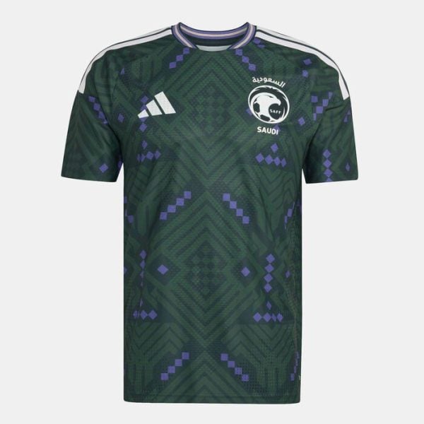 Dark green Saudi Arabia football jersey with purple geometric pattern, white Adidas logo on the chest, and the national team crest on the other side. White shoulder stripes visible.