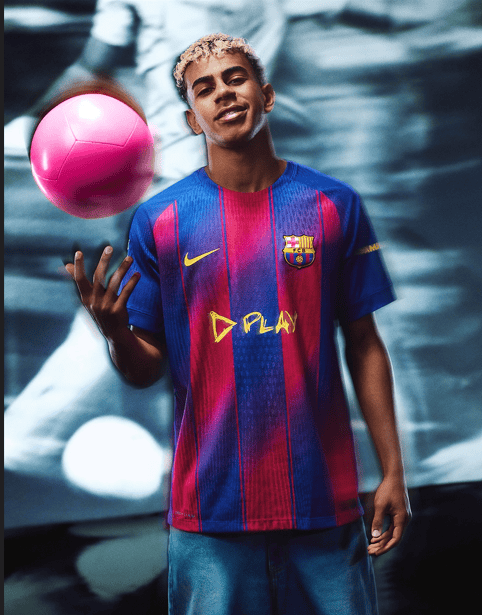 erg | AE JERSEY Young man in a Barcelona jersey juggling a pink soccer ball indoors.