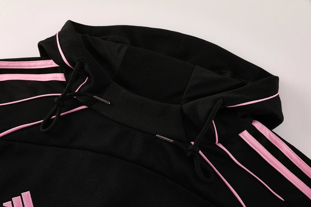 f44019a3 | AE JERSEY Close-up of a black hoodie with pink piping along the hood and sleeves, and pink drawstrings.