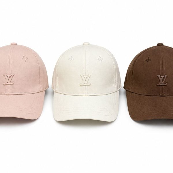 Three Louis Vuitton baseball caps in pink, white, and brown with the LV logo on the front panels.