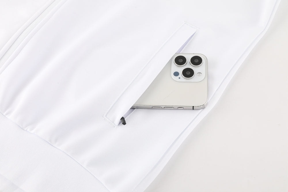 f9224105 | AE JERSEY White garment pocket holding a silver iPhone with a triple-camera setup peeking out of the pocket.