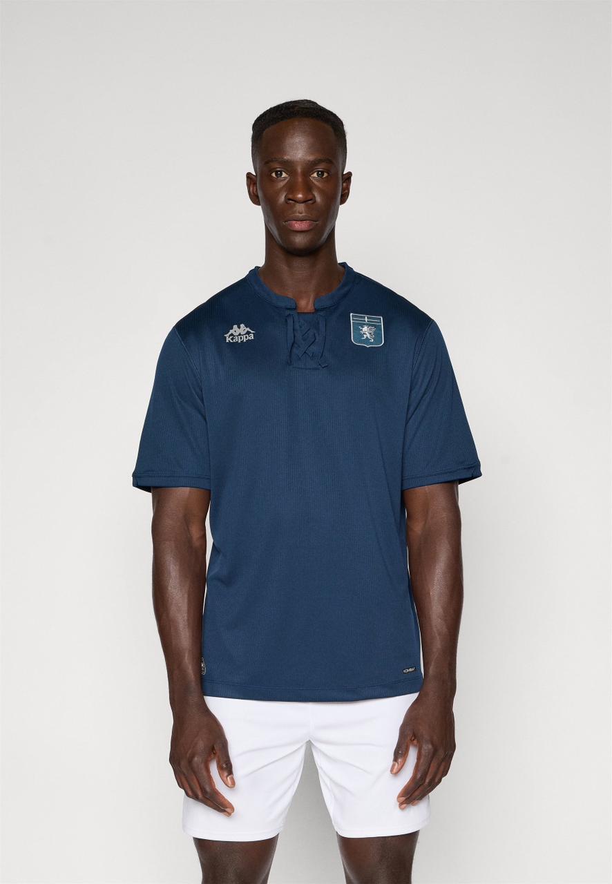 faa50979-1a01-4801-b573-6c553d965750 | AE JERSEY Male model in a navy blue short-sleeve sports shirt with a chest crest and Kappa logo, paired with white shorts.