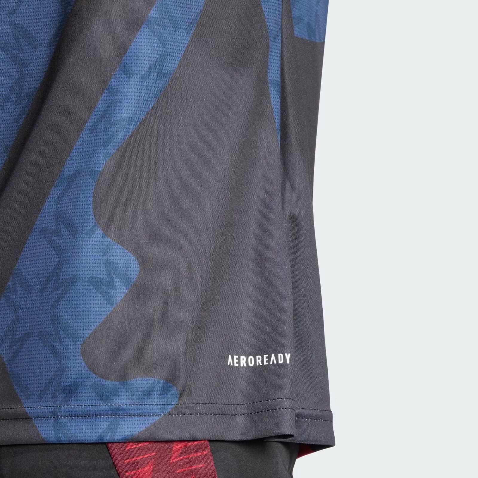 j1lJrkcKVd3EH8o | AE JERSEY Close-up of blue and black camouflage athletic fabric with 'AEROREADY' branding visible on the hem edge