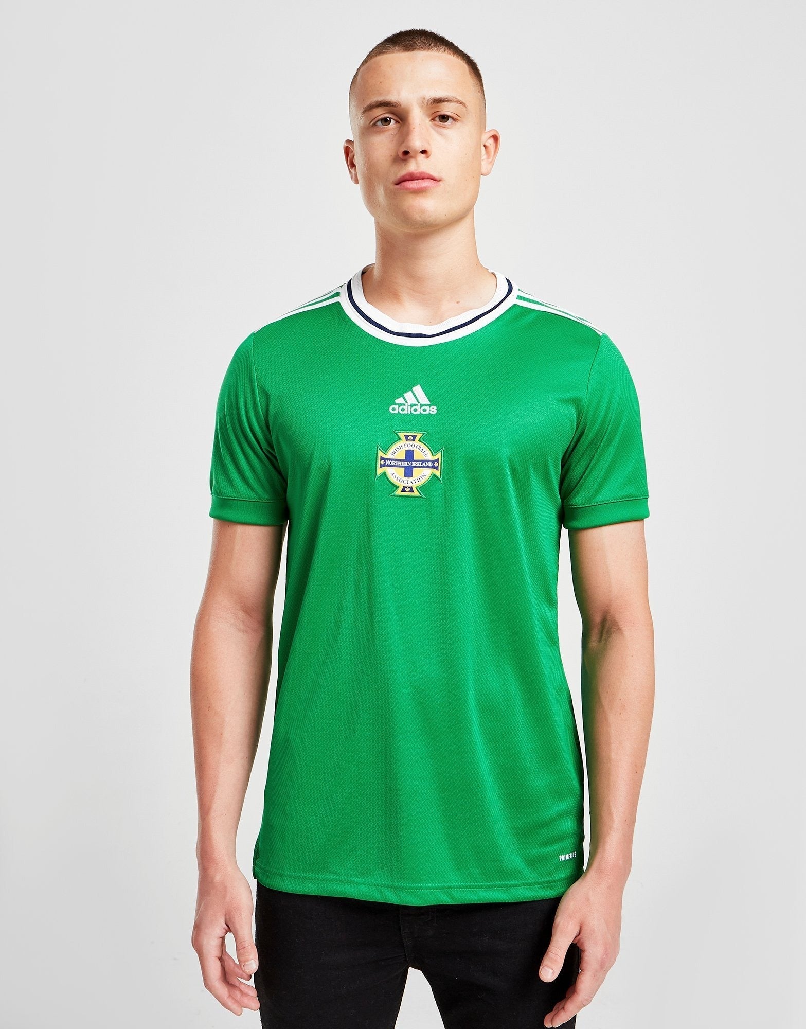 jd_516996_a_ceece25b-4209-4a85-8811-abf89aa914e7 | AE JERSEY Portrait of a young man wearing a green Northern Ireland football jersey, facing the camera against a light gray background.