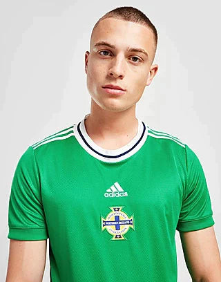 jd_product_list_151bcf2d-9065-4e87-aaf3-72b310282aec | AE JERSEY Portrait of a young man wearing a green Adidas football jersey with a crest featuring a cross.