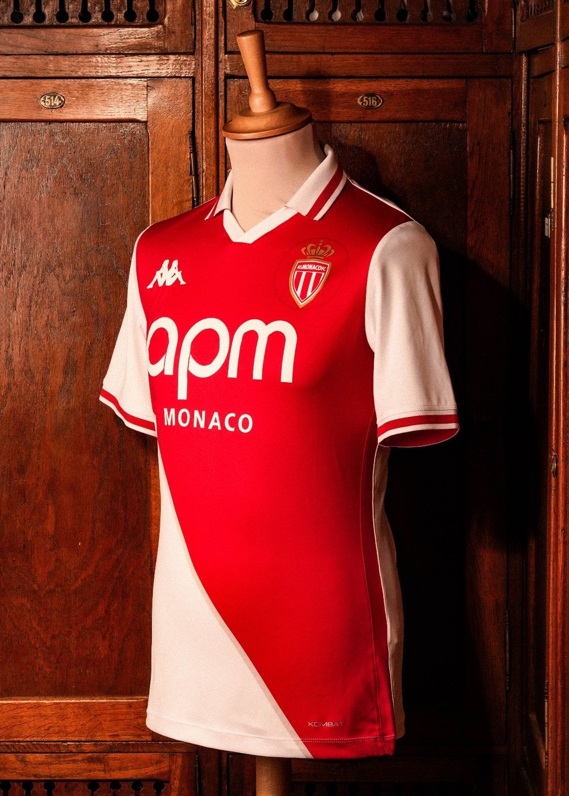 lmb8PjKUYubQeEA | AE JERSEY Red AS Monaco football jersey on a dress form, with Kappa logo and sponsor 'apm MONACO' displayed, set against wooden lockers.
