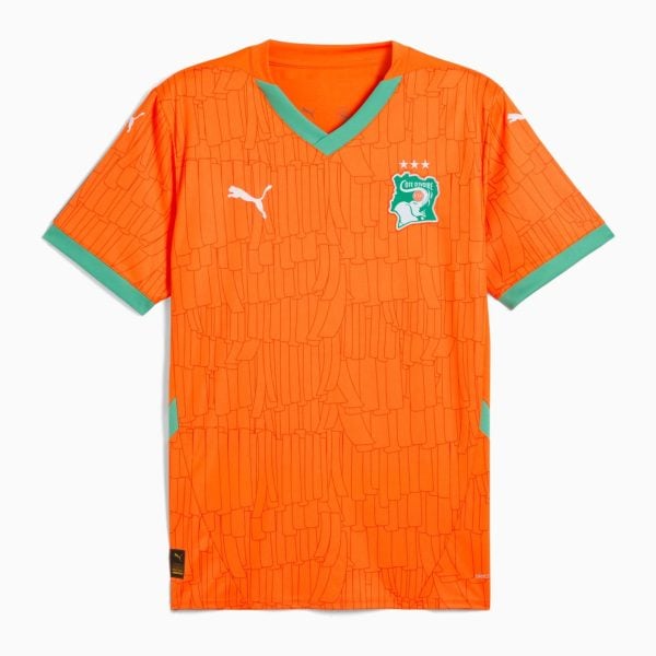 Orange football jersey with a green V-neck, Ivorians' crest on the left chest, white Puma logos, and teal-green sleeve cuffs with a repeating abstract pattern across the fabric.