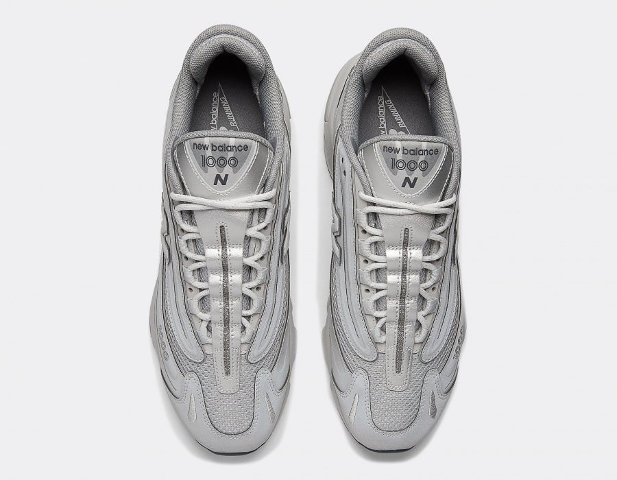 new-balance-m1000-te-reflective-pack-silver_5 | AE JERSEY Top-down view of two light gray New Balance sneakers side by side, showing laces and padded tongues with branding.