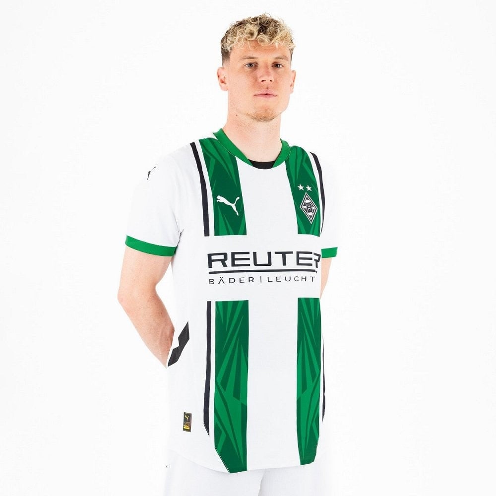 ojjXu1hc91BIp1C | AE JERSEY Man wearing a white Borussia Mönchengladbach football jersey with green vertical stripes and REUTER sponsor logo, standing against a white background.