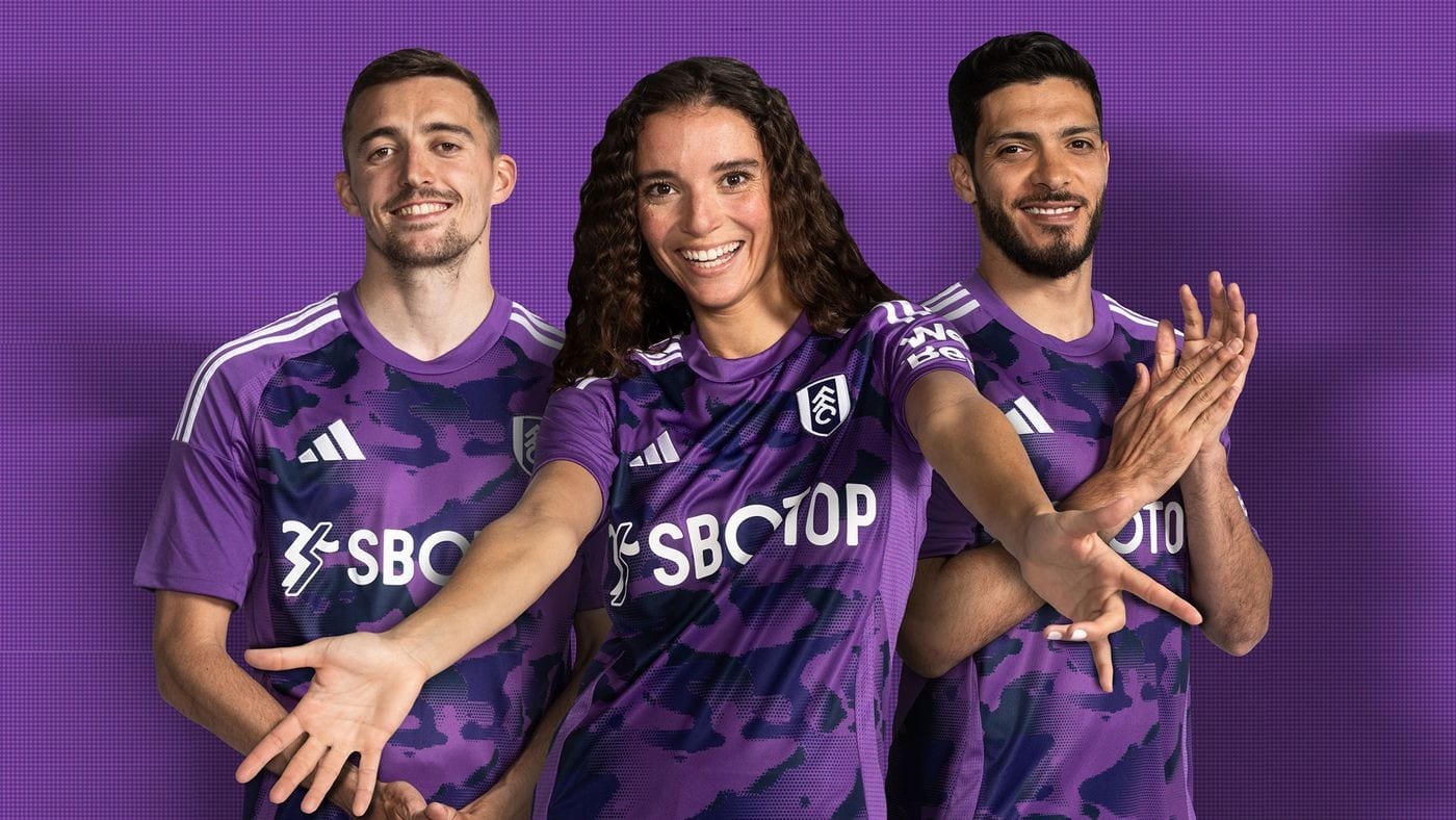 pP4Cz5a9aySX4XZ | AE JERSEY Three athletes in purple camouflage uniforms pose together and smile at the camera.