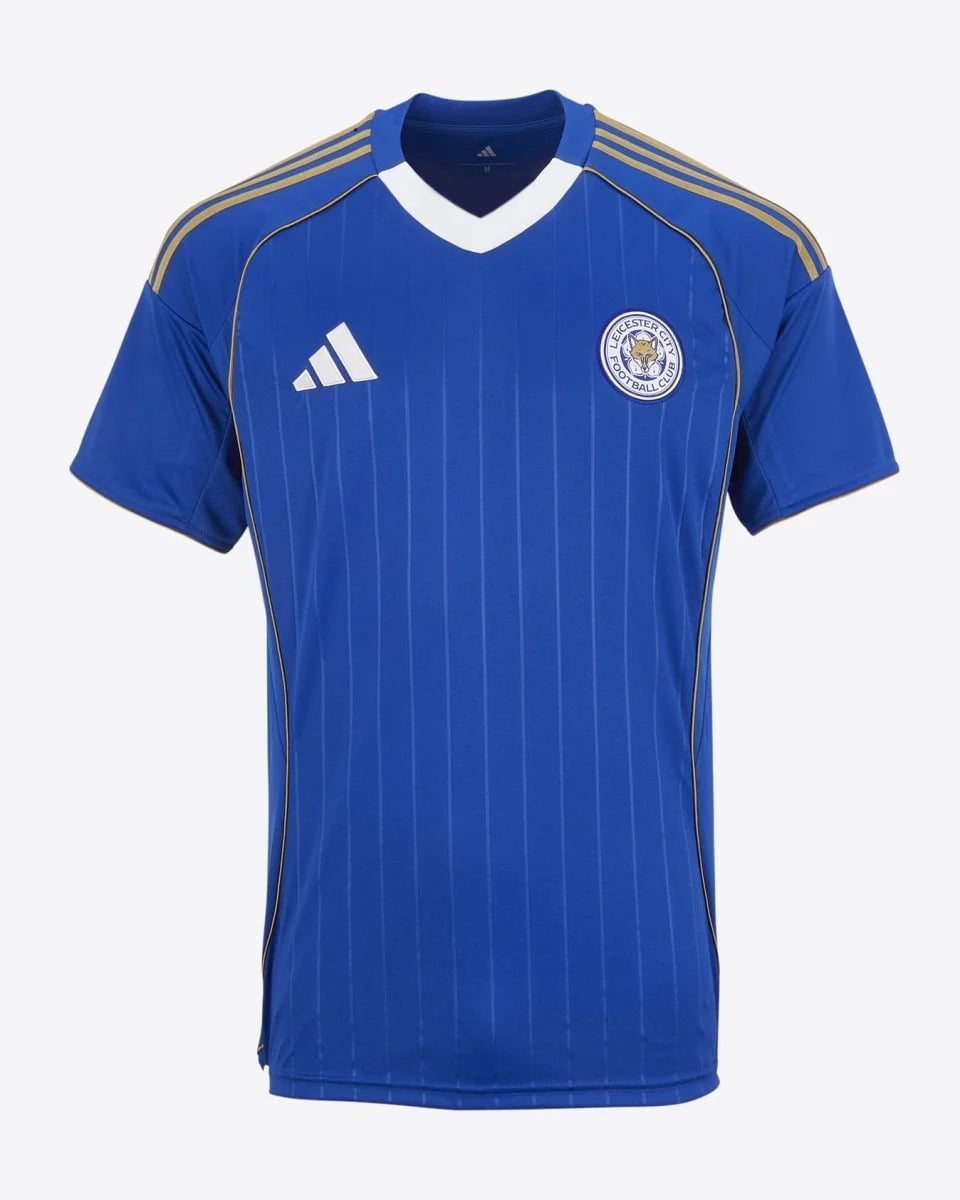 r9qeysmyzld2u38mpzwj | AE JERSEY Blue Leicester City football jersey with white V-neck, gold Adidas stripes on shoulders and club crest on the chest.