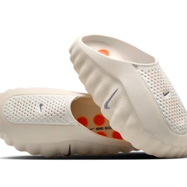 Cream-colored slip-on athletic shoes with perforated upper and wavy sole, Nike logo visible on side.