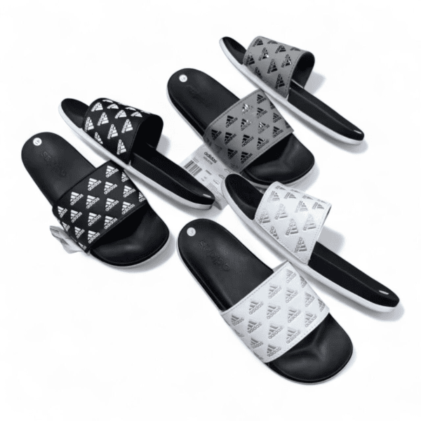 Assorted Adidas slide sandals in black, white, and gray with the brand logo on the straps, laid out on a white background.