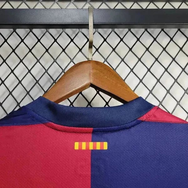 rn-image_picker_lib_temp_99b919ba-e8dd-4f97-9c44-0a6e0d000226 | AE JERSEY Red and blue soccer jersey on a wooden hanger, hanging on a wire mesh rack; a small yellow striped mark sits at the back near the collar.