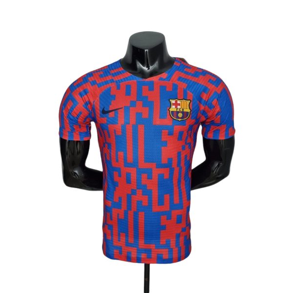 FC Barcelona soccer jersey on a black mannequin, blue and red geometric pattern with the club crest visible on the chest.