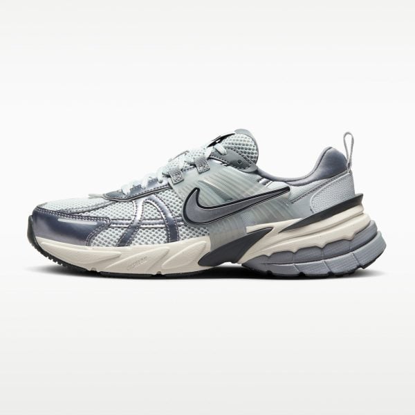 Close-up side view of a gray athletic running shoe with mesh upper, layered panels, and a chunky sole.