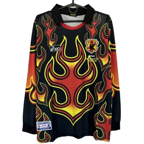 Black long-sleeve shirt with bright red-yellow flame pattern and black collar, sports jersey with JFA emblem and 'Japan World Cup 1998' text on chest