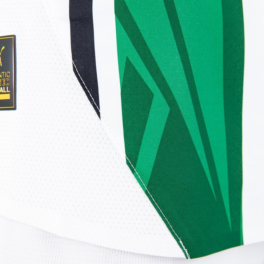 taGLWg9g9g8VCSD | AE JERSEY Close-up of a white mesh sports jersey with green panels and a small black-and-yellow brand patch on the left side, showing stitching detail.