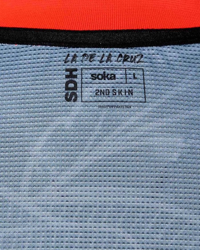 uYPDuWeKdkYXIfc | AE JERSEY Clothing tag showing brand text 'SODA' vertically, with 'soka' logo, size L, and '2ND SKIN' on a striped fabric background.